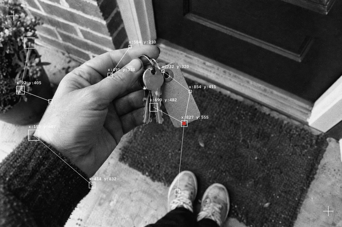 A hand holding the keys to a newly bought home at the front door